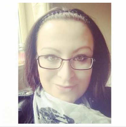 A woman with brown hair wearing glasses