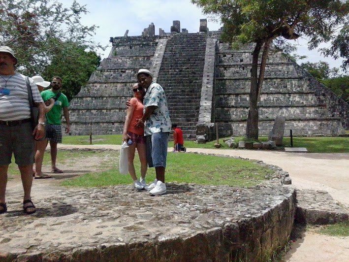 husband and wife hugging in front of mayan pyramid