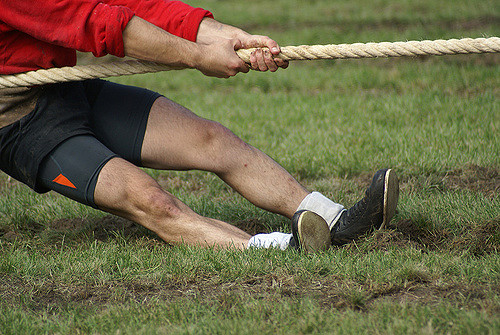 men playing tug of war with a thick rope