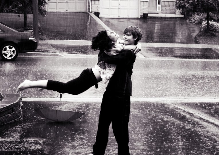 Boy and girl hugging in the rain