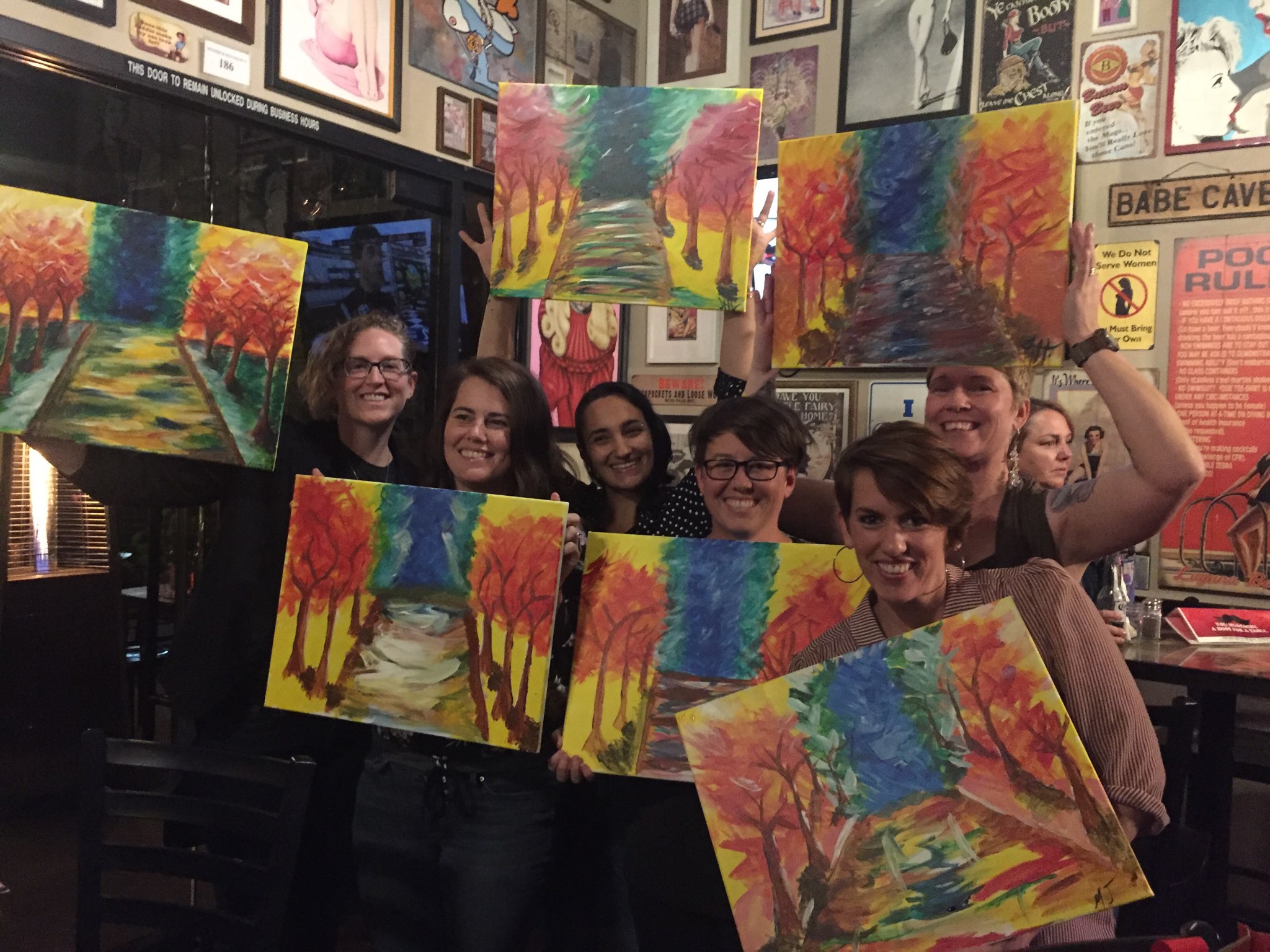 Group photo of everyone holding up their tree paintings