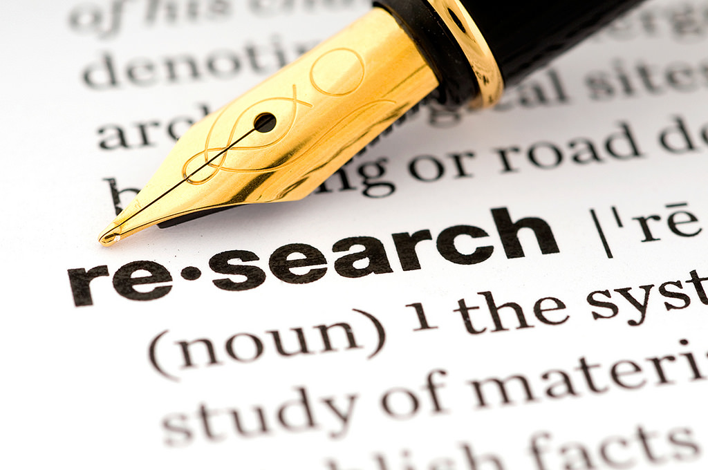 A fountain pen resting on a page containing the definition of research