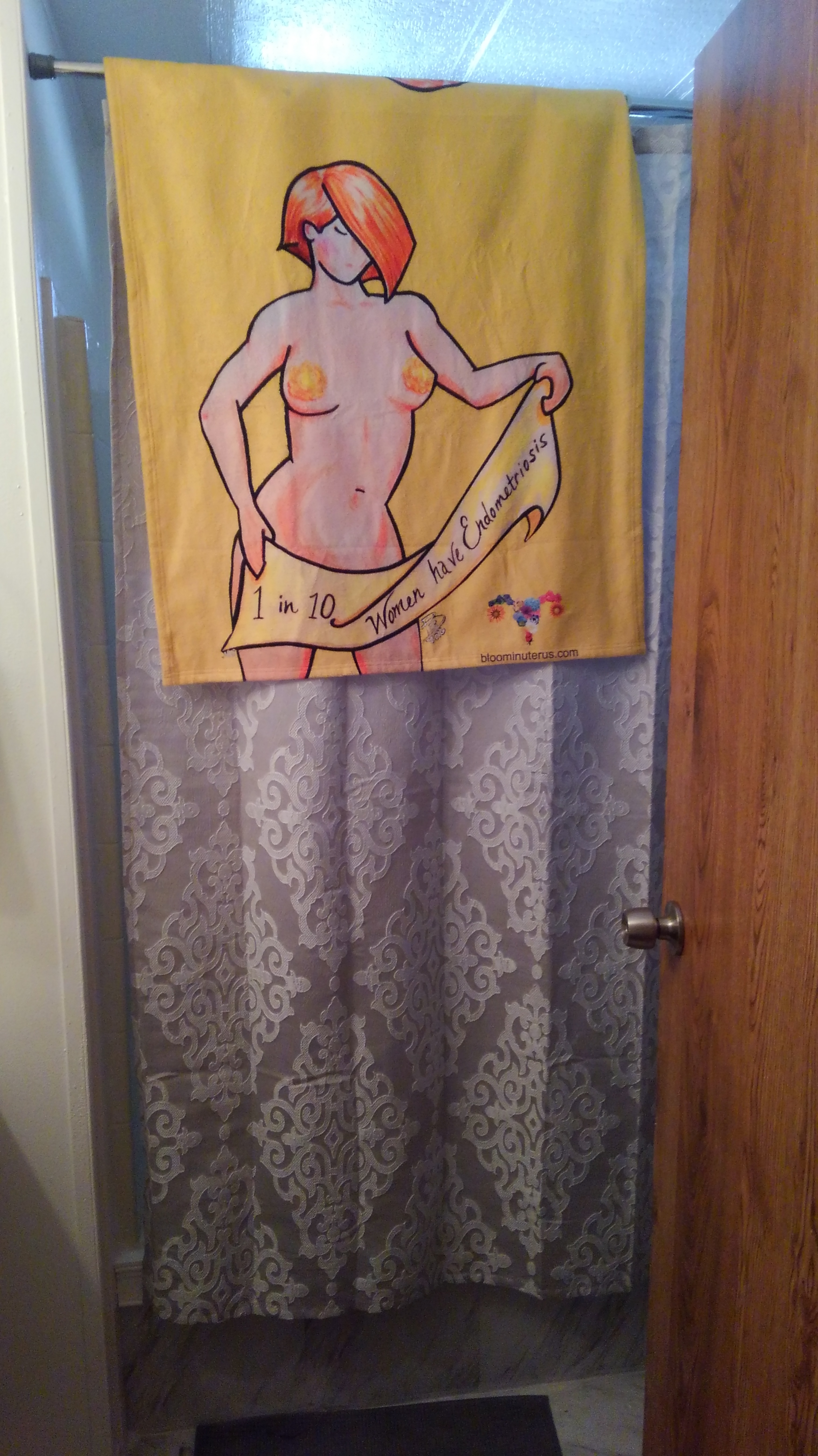 Bloomin' Uterus Endometriosis Awareness beach towel hanging from a shower curtain rod