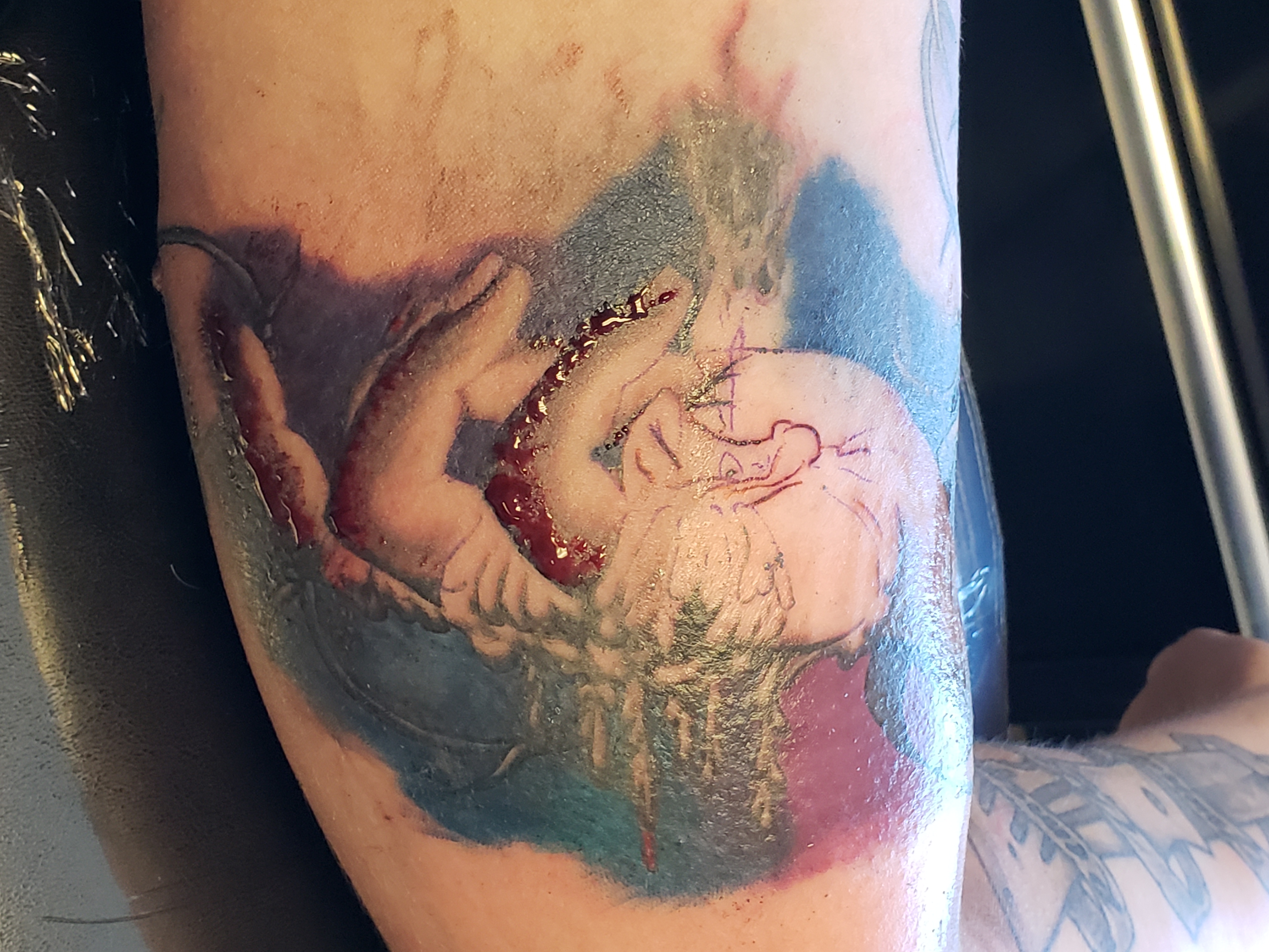 Close up of tattoo in progress; covered in blood