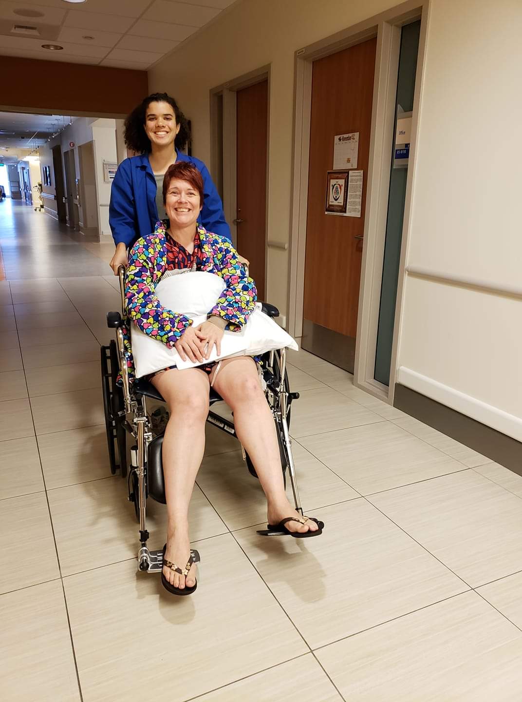 Lisa Howard and nurse being wheeled down the hallway of hospital on way home after surgery