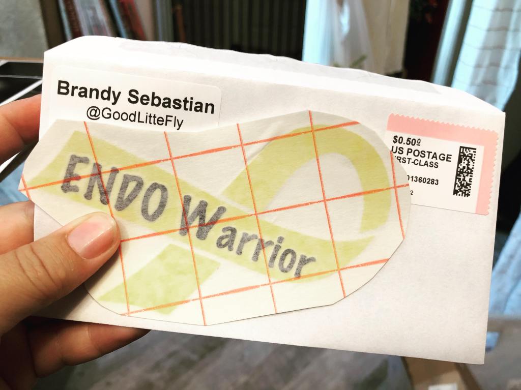 Yellow ribbon EndoWarrior decal in front of an unsealed mailing envelope