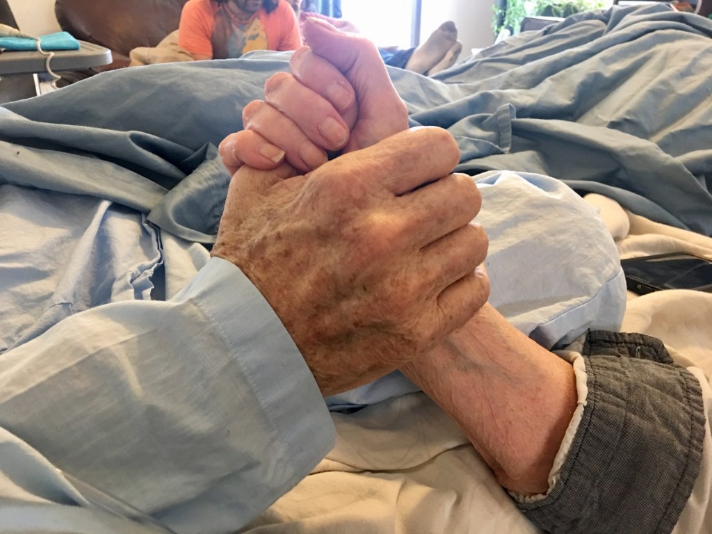 Uncle Wally holding Aunty Mona's hand.